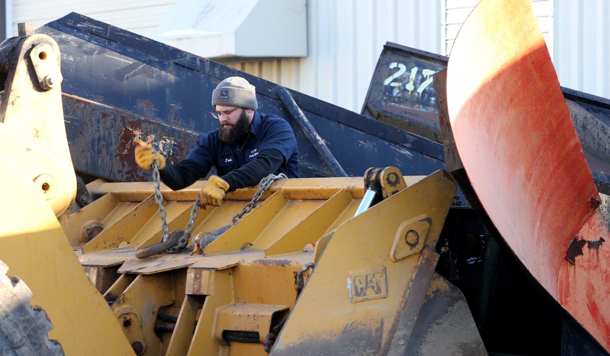 Josh Shank secures the V-blade of a snow plow to a front-end loader to position it for the upcoming winter storm Tuesday, Dec. 20, 2022, at the St. Joseph County Highway Department’s Woodland District facility on New Road near Indiana 331.