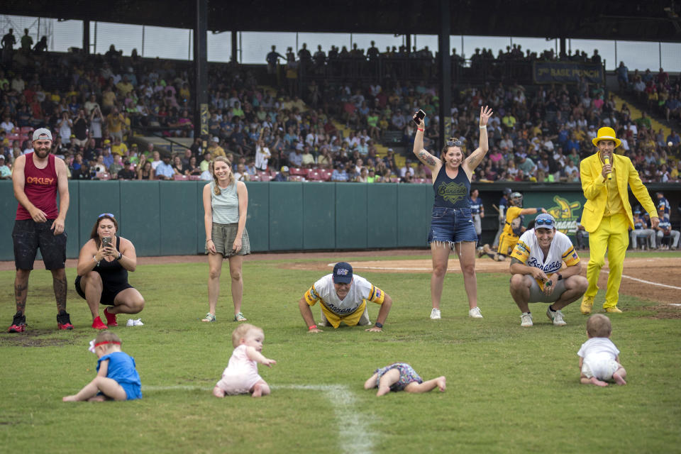 FILE - Four infants and their parents take part in what the Savannah Bananas call The Slowest Race, at the team's baseball game against the Wilmington Sharks, Saturday, June 11, 2022, in Savannah, Ga. At far right is Savannah Bananas owner Jesse Cole. The Savannah Bananas, who became a national sensation with their irreverent style of baseball, are leaving the Coastal Plains League to focus full attention on their professional barnstorming team. Owner Jesse Cole made the announcement in a YouTube video, saying “we'll be able to bring the Savannah Bananas to more people in Savannah and around the world."(AP Photo/Stephen B. Morton, File)