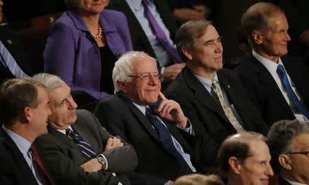 Democratic U.S. presidential candidate Bernie Sanders smiles as he listens to U.S. President Barack Obama's State of the Union address to a joint session of Congress in Washington, January 12, 2016. REUTERS/Carlos Barria