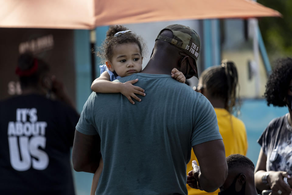 Aria Bennett rests on the shoulder of her father, Shernovius Bennett, at the John Lewis Advancement Act Day of Action, a voter education and engagement event Saturday, May 8, 2021, at King's Canvas in Montgomery, Ala. The Bennetts were there to show their support for voting rights. (AP Photo/Vasha Hunt)