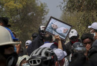 A man holds a picture of Kyal Sin during her burial in Mandalay, Myanmar, Thursday, March 4, 2021. Kyal Sin was shot in the head by Myanmar security forces during an anti-coup protest rally she was attending Wednesday. (AP Photo)