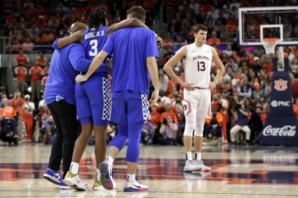 Kentucky guard TyTy Washington Jr. (3) is helped off the court after an injury during the first half of an NCAA college basketball game against Auburn Saturday, Jan. 22, 2022, in Auburn, Ala. (AP Photo/Butch Dill)