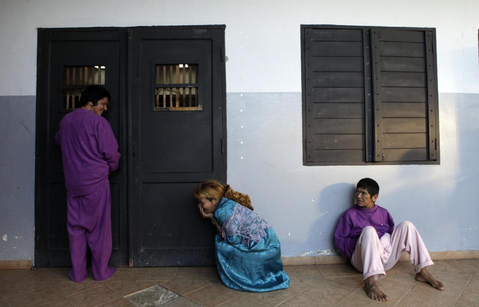 In this May 29, 2013 photo, patients wait for breakfast inside a bedroom at the Neuro-Psychiatric Hospital in Asuncion, Paraguay. Hospital Director Teofilo Villalba said its patients come from Paraguay's lower and middle classes and "they can't be kept without nutritious food because they would go into a crisis. No one can recover while hungry. When the rich get sick here, they’re treated at private hospitals or are sent abroad." (AP Photo/Jorge Saenz)