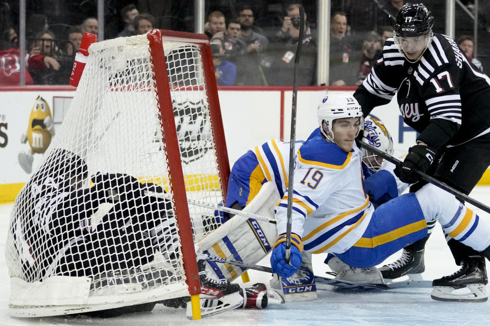 New Jersey Devils left wing Miles Wood (44) crashes into the goal on a scoring attempt on Buffalo Sabres goaltender Devon Levi during the second period of an NHL hockey game, Tuesday, April 11, 2023, in Newark, N.J. (AP Photo/John Minchillo)