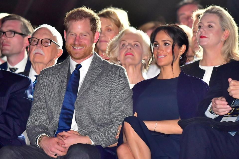 <p>Prince Harry holds Meghan's hand on his lap.</p>