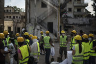 Volunteers from the American University of Beirut gather as they prepare to help remove debris in a neighborhood near the site of last week's explosion that hit the seaport of Beirut, Lebanon, Thursday, Aug. 13, 2020. (AP Photo/Felipe Dana)