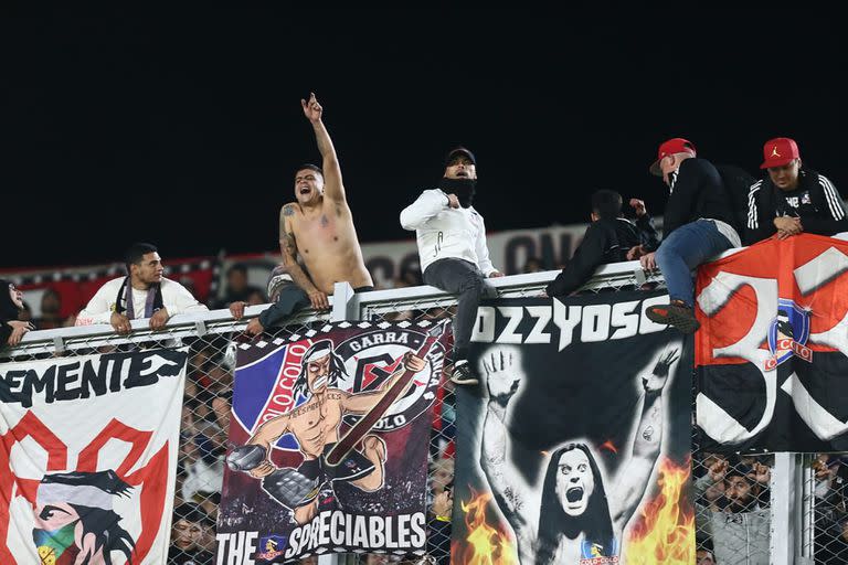 Hinchas de Colo Colo subidos al acrílico del Monumental demoraron el reinicio del partido con River y parecieron desconcertar a sus jugadores, que les pidieron bajarse.