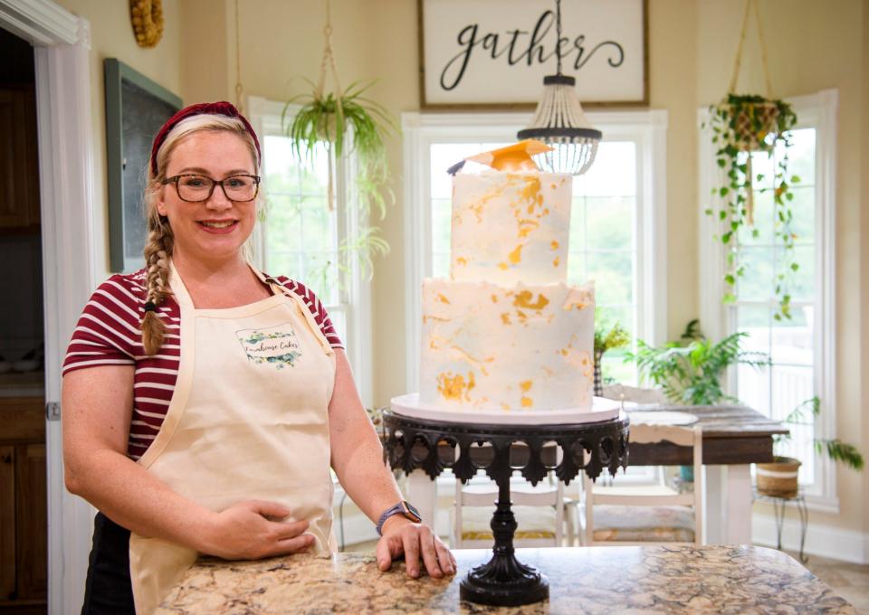 Alison Ballman poses in her kitchen with a graduation cake she made on Friday, June 10, 2022.