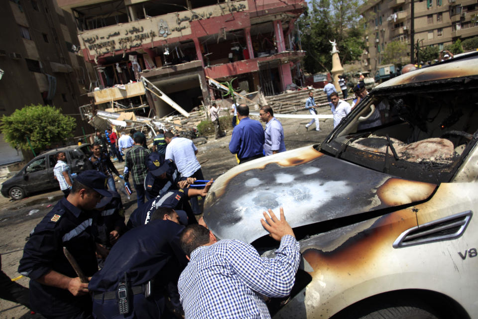 FILE - In this file photo taken Thursday, Sept. 5, 2013, Egyptian security forces check a damaged car that was hit by a bomb attack targeting the convoy of Egypt's Interior Minister Mohammed Ibrahim, in Nasr City, Cairo, Egypt. The militant group Ansar Beit al-Maqdis, which has waged a campaign of bombings and assassinations for months in Egypt, has quickly advanced in weaponry and sophistication of attacks, drawing on the experience of Egyptians who fought in Syria. (AP Photo/Khalil Hamra, File)