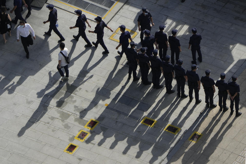 Security personnel march to duty outside the Evergrande headquarters in Shenzhen, China, Friday, Sept. 24, 2021. Things appeared quiet at the headquarters of the heavily indebted Chinese real estate developer Evergrande, one day after the day it had promised to pay interest due to bondholders in China. (AP Photo/Ng Han Guan)