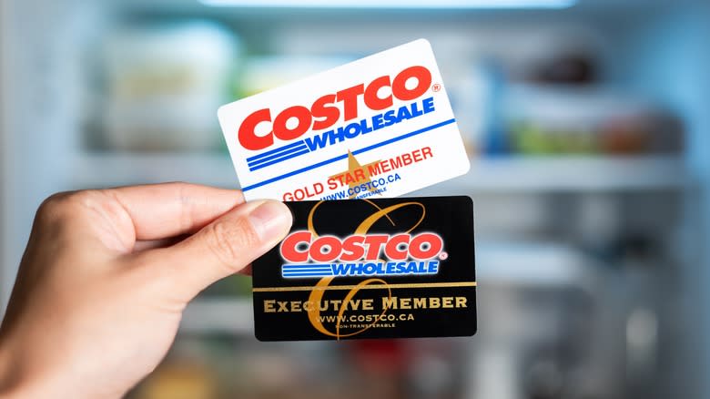 person holding Costco membership cards