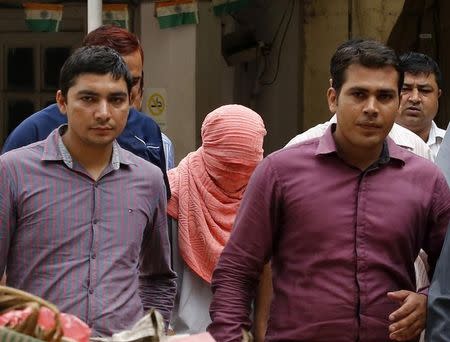 Plainclothes policemen escort an Indian teenager (head covered with towel) after he was sentenced at a juvenile court in New Delhi August 31, 2013. REUTERS/Anindito Mukherjee