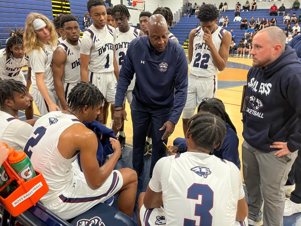 Dwyer coach Fred Ross, whose team is seeking back-to-back state titles, huddles with his team Thursday night.