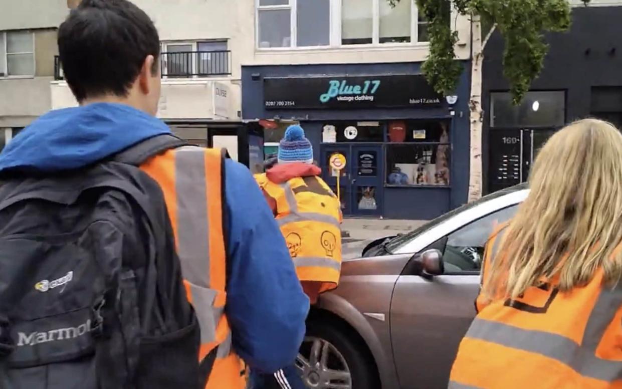 Footage posted online showed the protester stumbling backwards after a car drives past - Twitter