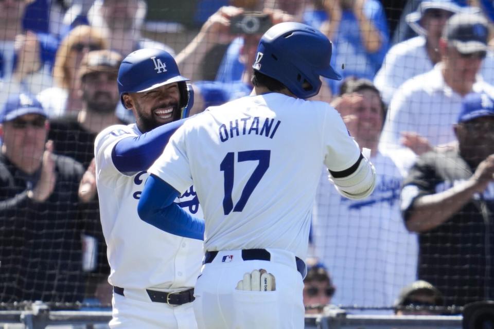 Shohei Ohtani greets Dodgers teammate Teoscar Hernández after hitting a home run during the eighth inning Sunday.