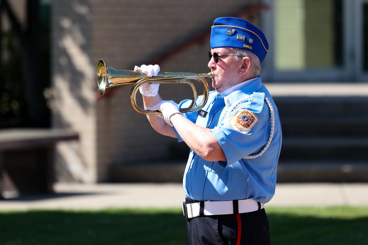 VFW Post 1055 Auxiliary member Beth Clark plays Taps outside on the Portage County Courthouse lawn in Ravenna for a short Memorial Day ceremony in 2022. This year's parade will make a stop at the veteran's memorial this year. 
Credit: Nick McLaughlin, Special to The Record-Courier