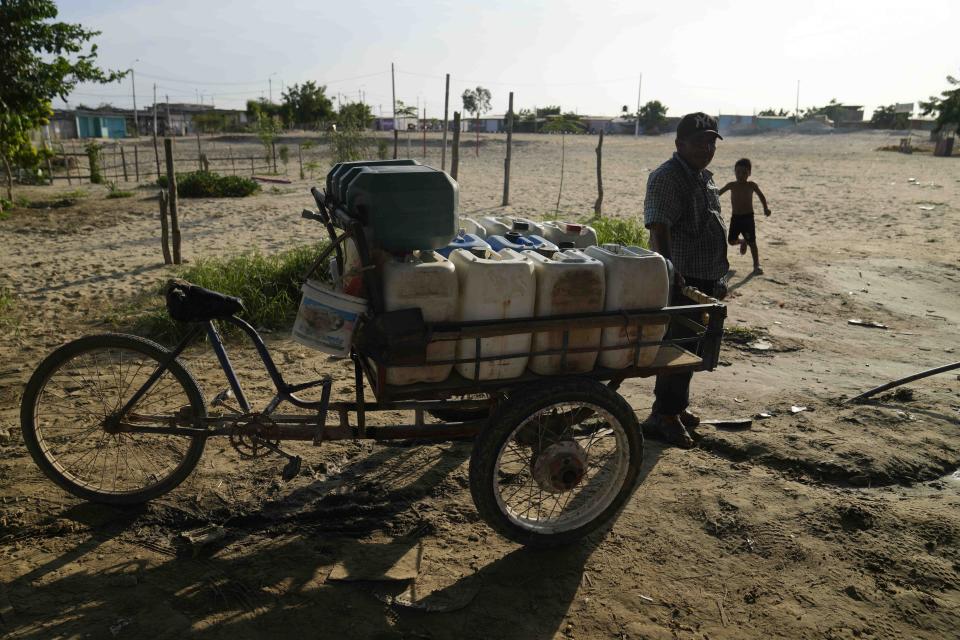 Un hombre espera su turno para rellenar de agua varios recipientes en Piura, Perú, el jueves 29 de febrero de 2024. Perú declaró la emergencia de salud en la mayoría de sus regiones el 26 de febrero ante el aumento de casos de dengue. (AP Foto/Martín Mejía)