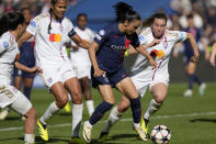 PSG's Sakina Karchaoui, center, troies to score but loses the ball to a Lyon defender during the women's Champions League semifinal, second leg, soccer match between Paris Saint-Germain and Olympique Lyonnais at Parc des Princes, in Paris, Sunday, April 28, 2024. (AP Photo/Thibault Camus)