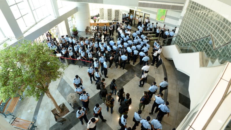 Police officers gather at the headquarters of Apple Daily in Hong Kong