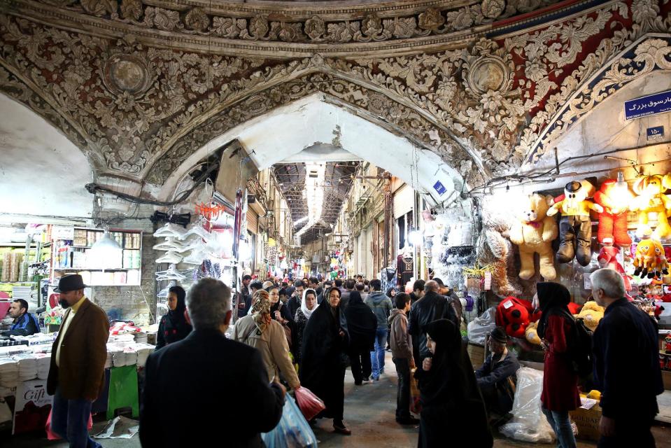 In this picture taken on Tuesday, March 18, 2014, Iranians walk through Tehran's old main bazaar, ahead of the Iranian New Year, or Nowruz, in downtown Tehran, Iran. Nowruz which means "New Day" in Persian, marks the first day of spring and the beginning of the year on the Iranian calendar, which occurs exactly on the Spring Equinox, and usually begins on March 21 or the previous or following day. (AP Photo/Ebrahim Noroozi)