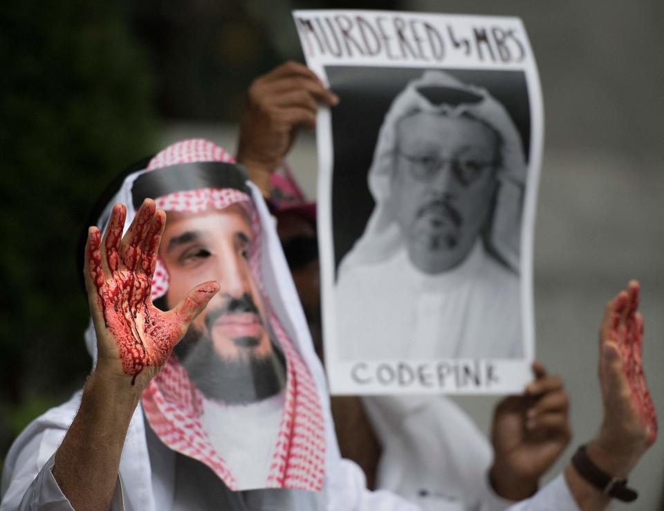 In this file photo taken on 10 October 2018, a demonstrator dressed as Saudi Arabian crown prince Mohammed bin Salman  with blood on his hands protests outside the Saudi Embassy in Washington, DC, demanding justice for missing Saudi journalist Jamal Khashoggi (AFP via Getty Images)
