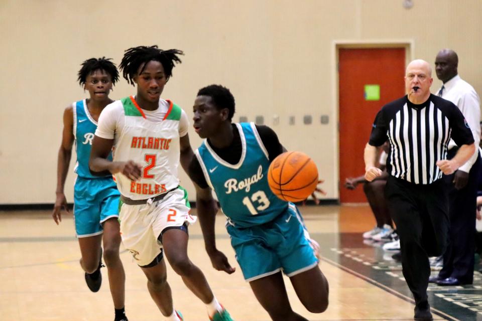 Royal Palm Beach junior Michael Vilsaint runs under the pressure of Atlantic’s Alix Dieudonne in the Wildcats’ 73-66 win at Atlantic High on November 22, 2023.