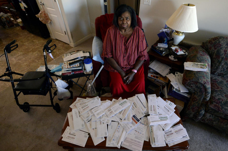 Debra Smith, 57, sits with her medical bills in her living room on Thursday, Oct. 7, 2021, in Spring Hill, Tenn. Smith, who has health problems that prevent her from working, has about $10,000 in unpaid medical bills. Patient advocates and some state governments say hospitals must do more to help patients deal with medical bills before the debt winds up in collections. (AP Photo/Mark Zaleski)