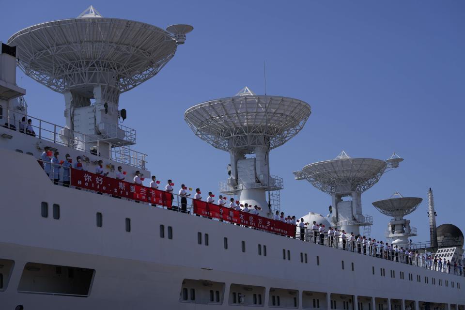 Crew of Chinese scientific research ship Yuan Wang 5 wave Chinese flags from the ship after arriving at Hambantota International Port in Hambantota, Sri Lanka, Tuesday, Aug. 16, 2022. The ship was originally set to arrive Aug. 11 but the port call was deferred due to apparent security concerns raised by India. (AP Photo/Eranga Jayawardena)