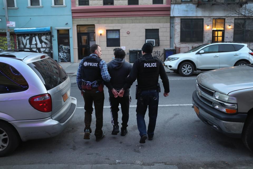 U.S. Immigration and Customs Enforcement officers arrest a person during a raid in Brooklyn in April 2018. Experts say there are far more people present in the U.S. than will ever be located by immigration officers.