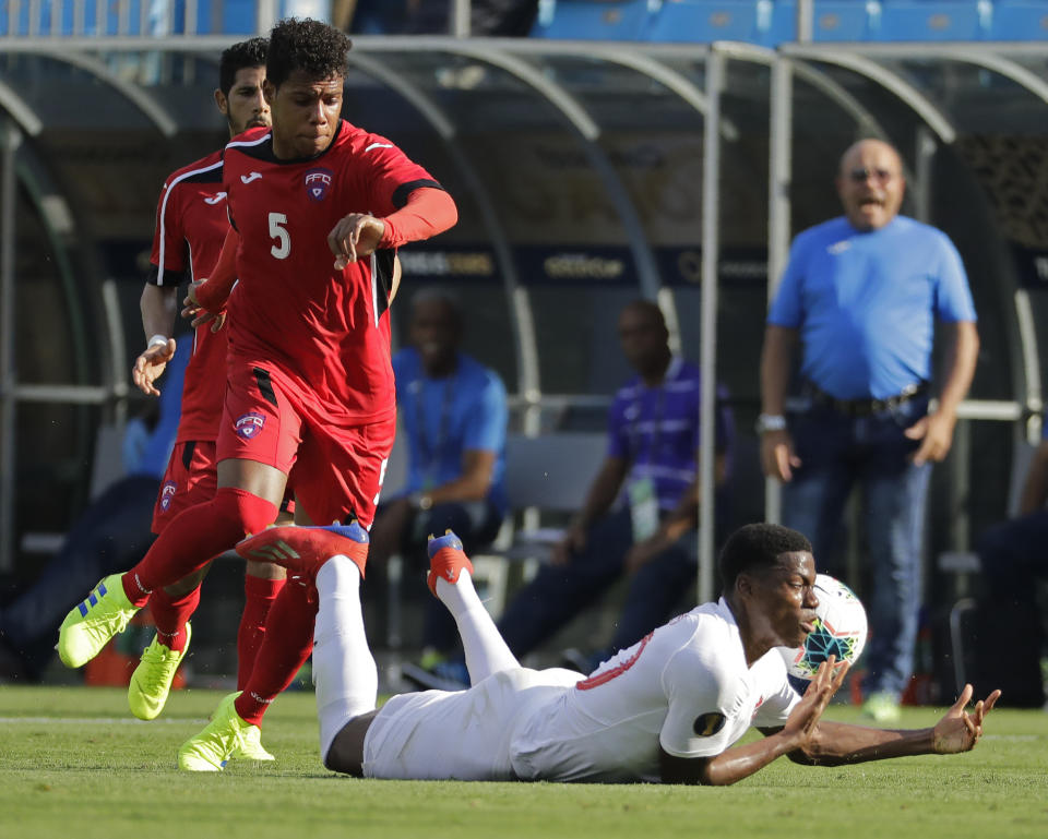 Canada's Jonathan David, right, is fouled by Cuba's Daniel Morejon (5) during the first half of a CONCACAF Golf Cup soccer match in Charlotte, N.C., Sunday, June 23, 2019. (AP Photo/Chuck Burton)