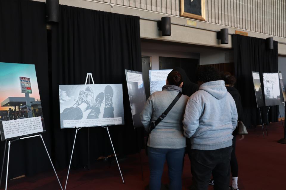 Guests view images taken by Brockton High School junior Tayha Lesperance at the 2024 PhotoVoice art exhibition held in the Brockton High fine arts lobby on April 24.