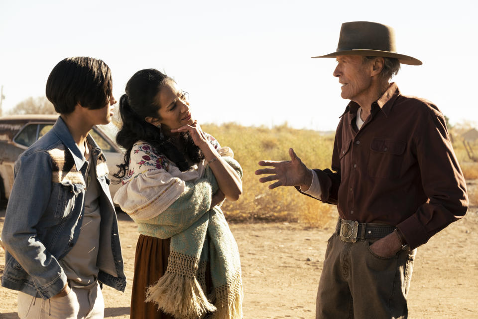 This image released by Warner Bros. Pictures shows Eduardo Minett, from left, Natalia Traven and Clint Eastwood in a scene from "Cry Macho." (Claire Folger/Warner Bros. Pictures via AP)