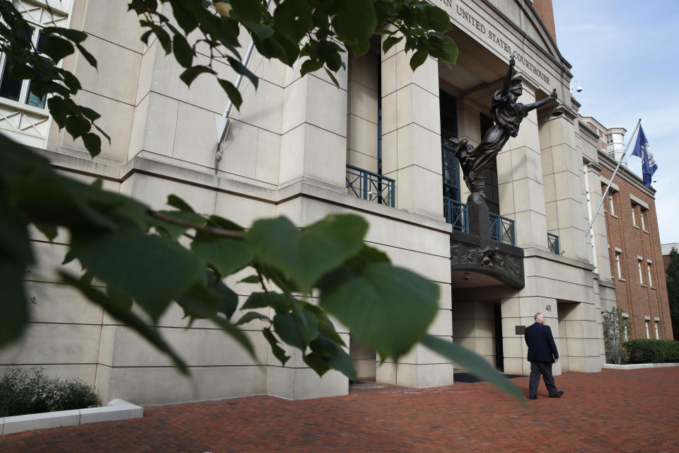 A security guard walks by the front of federal court as jury deliberations begin in the trial of the former Trump campaign chairman, in Alexandria, Va., Thursday, Aug. 16, 2018. (AP Photo/Jacquelyn Martin)