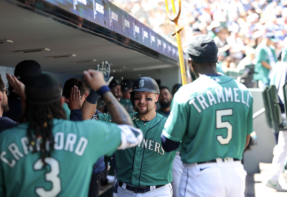 Seattle Mariners' Cal Raleigh, center, celebrates with teammates after his solo home run during the third inning of a baseball game against the Toronto Blue Jays, Saturday, July 22, 2023, in Seattle. (AP Photo/Jason Redmond)