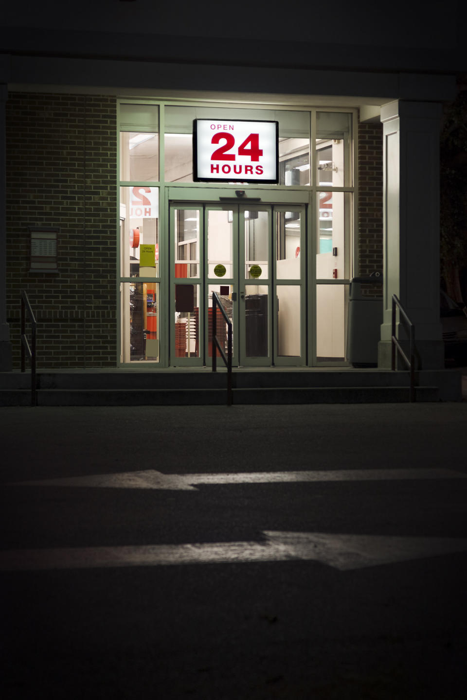 A store with a lit up 24-hour sign.