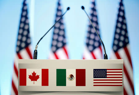 FILE PHOTO: The flags of Canada, Mexico and the U.S. are seen on a lectern before a joint news conference on the closing of the seventh round of NAFTA talks in Mexico City, Mexico, March 5, 2018. REUTERS/Edgard Garrido/File Photo