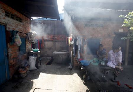 A woman prepares food at a building where garment workers live, in a suburb of Phnom Penh August 17, 2014. REUTERS/Samrang Pring