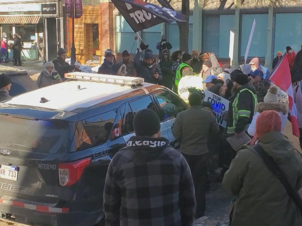 Protesters swarm a police vehicle Saturday after a protester was arrested. (Shane Fowler/CBC - image credit)