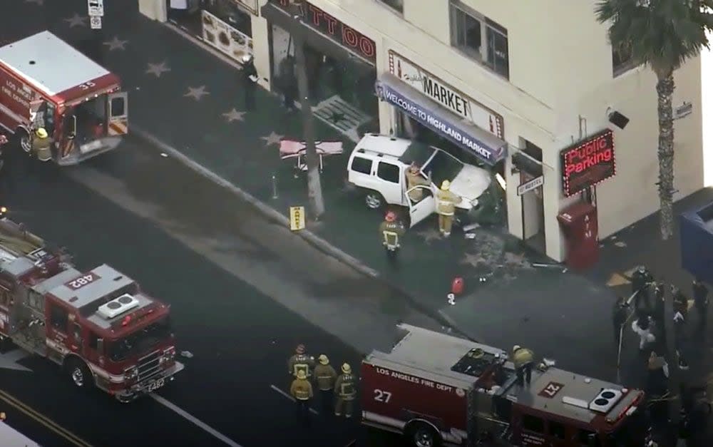 This aerial screenshot released by FOX 11 KTTV shows Los Angeles firemen at the scene of an accident on West Hollywood Boulevard in the Hollywood district of Los Angeles, Friday, March 19, 2021. (FOX 11 KTTV via AP)