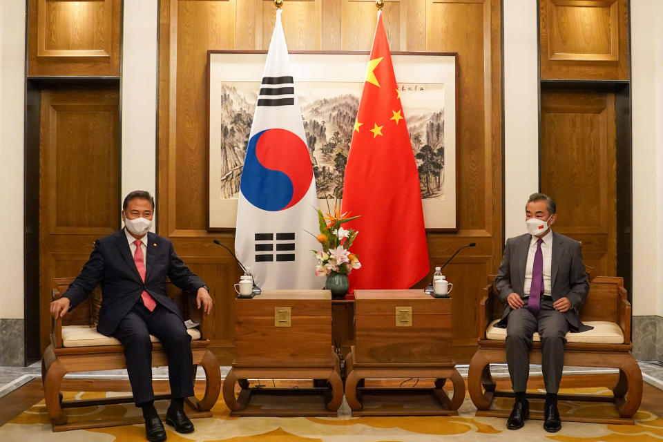 In this photo provided by South Korea Foreign Ministry, South Korean Foreign Minister Park Jin, left, talks with his Chinese counterpart Wang Yi during their meeting in Qingdao, China, Tuesday, Aug. 9, 2022. (South Korea Foreign Ministry via AP)