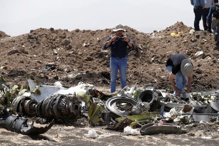 FILE PHOTO: American civil aviation and Boeing investigators search through the debris at the scene of the Ethiopian Airlines Flight ET 302 plane crash, near the town of Bishoftu, southeast of Addis Ababa