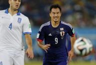 Japan's Shinji Okazaki runs for the ball ahead of Greece's Kostas Manolas during their 2014 World Cup Group C soccer match at the Dunas arena in Natal June 19, 2014. REUTERS/Sergio Moraes (BRAZIL - Tags: SOCCER SPORT WORLD CUP)