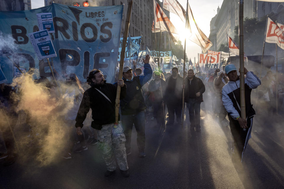 People walk towards the Plaza de Mayo in a march organized by social organizations representing the unemployed to protest against the government's economic policy, in Buenos Aires, Argentina, Thursday, May 12, 2022. Social organizations in Argentina are helping the neediest survive day-to-day and prevent explosive social conflict. But they also pose a threat to the government because of their ability to organize massive protests for more assistance, and other demands. (AP Photo/Rodrigo Abd)