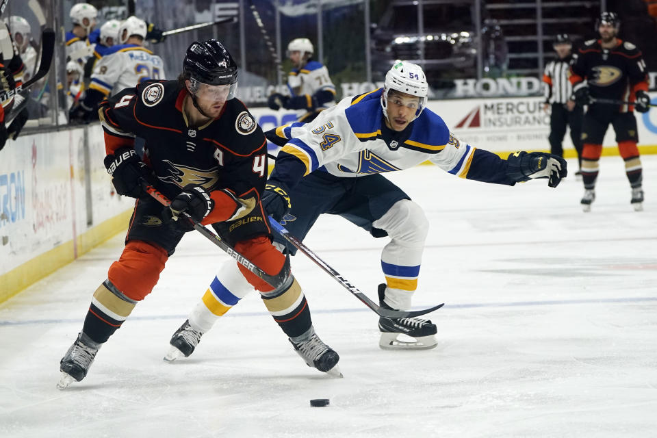 Anaheim Ducks defenseman Cam Fowler (4) reaches for the puck in front of St. Louis Blues center Dakota Joshua (54) during the third period of an NHL hockey game Wednesday, March 3, 2021, in Anaheim, Calif. (AP Photo/Marcio Jose Sanchez)