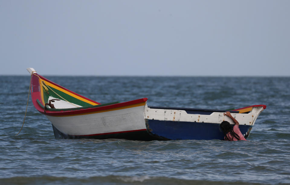 A girl holds on to a boat while playing near where Maroly Bastardo disappeared in the Caribbean Sea, in Guiria, Venezuela, on May 24. (Photo: Ivan Alvarado/Reuters)