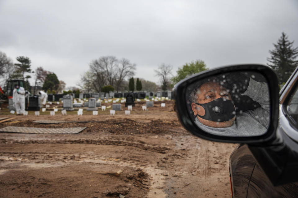 Michael Tokar observes from his car as his father, David Tokar, is buried at Mount Richmond Cemetery in the Staten Island borough of New York, Wednesday, April 8, 2020. Tokar's father had a cough and fever and a home health aide got him to the hospital. Two days later, he was dead, with the coronavirus listed as the cause. (AP Photo/David Goldman)