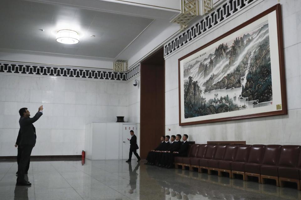 In this Friday, March 3, 2017 a fire extinguisher is seen on a corner as a delegate takes a picture of a painting inside the Great Hall of the People during the Chinese People's Political Consultative Conference (CPPCC) in Beijing. Because safety comes first, fire extinguishers are ubiquitous in and around Beijing’s Great Hall of the People during the annual sessions of China’s ceremonial parliament and its official advisory body. That’s partly for standard purposes of preventing any sort of fire-related emergency that could harm the participants and mar the proceedings. (AP Photo/Andy Wong)