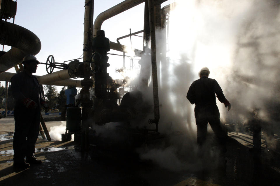 FILE - In this Nov. 17, 2007 file photo, a worker repairs a part of a unit of the Tehran oil refinery, in Tehran, Iran. Iran is preparing for the return of U.S. sanctions Nov. 5 that will hit its multi-billion dollar oil exports. Iran is bracing for the restoration of U.S. sanctions on its vital oil industry set to take effect on Monday, Nov. 5, 2018, as it grapples with an economic crisis that has sparked sporadic protests over rising prices, corruption and unemployment. The oil sanctions will target the country’s largest source of revenue in the most punishing action taken since the Trump administration withdrew from the 2015 nuclear agreement in May. (AP Photo/Vahid Salemi, File)