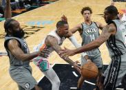 San Antonio Spurs guard Dejounte Murray, second from left, drives to the basket between Brooklyn Nets guard James Harden (13) and center LaMarcus Aldridge (21) during the second half of an NBA basketball game, Friday, Jan. 21, 2022, in San Antonio. (AP Photo/Eric Gay)