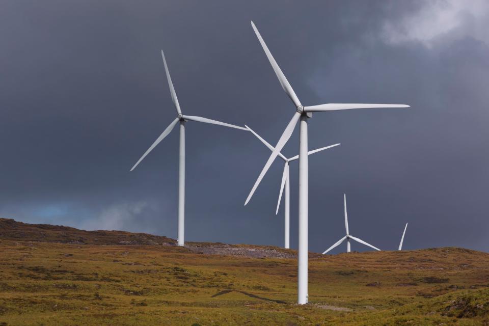 Wind turbines spin amid dark weather clouds in Ireland